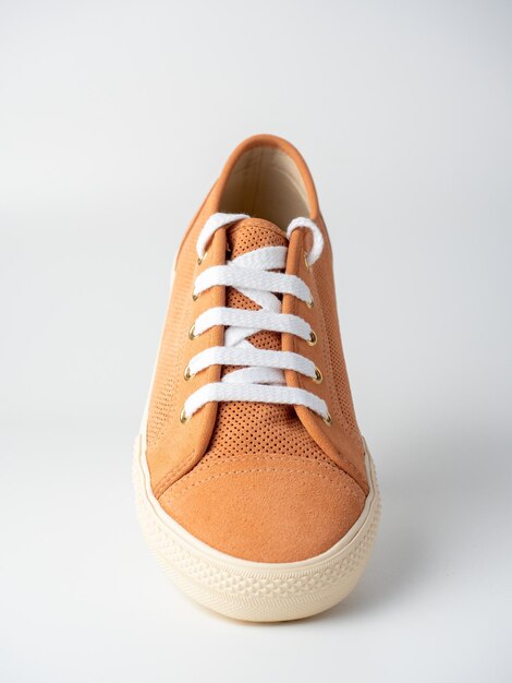 Close-up of new light brown sneakers with white laces on a white background. Nubuck suede leather.