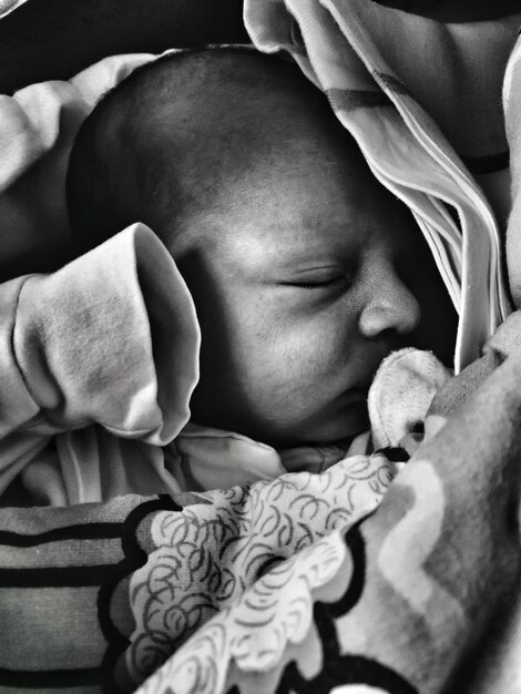 Foto close-up di un neonato che dorme sul letto