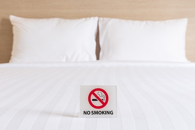 Photo close up no smoking sign on the bed in hotel room