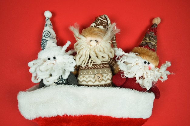 Рождественские гномы ноэля выглядывают из шляпы санта-клауса крупным планом