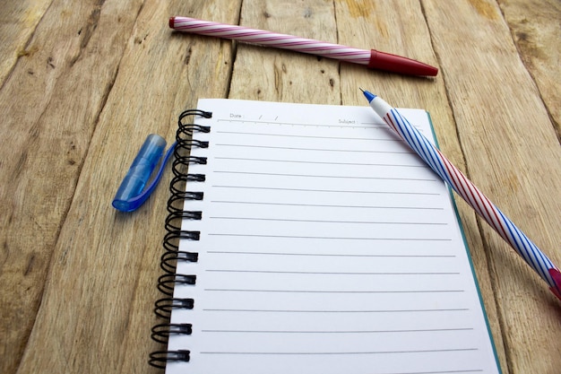 close-up of notebook and pens on table