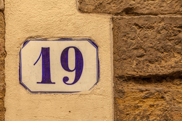 Photo close-up of number 19 on yellow wall