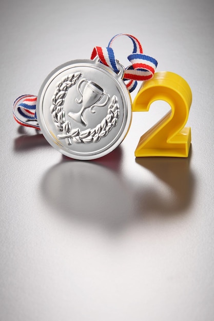 Close-up of number 2 with silver medal on gray background
