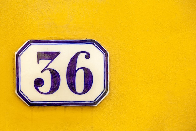 Photo close-up of number 36 on yellow wall