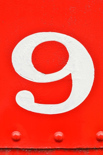 Foto close-up del numero 9 sul metallo rosso