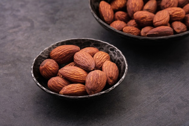 Close-up nuts almonds in black bowl