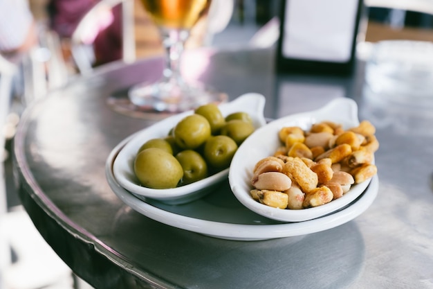 Close-up of nuts and olives in plate on table