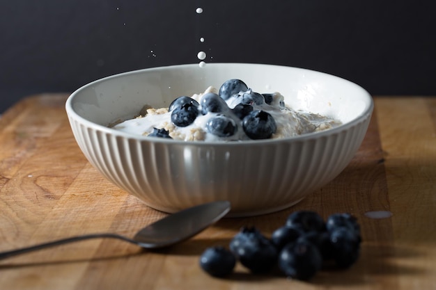 Photo close-up of oatmeal bowl with blueberries on table