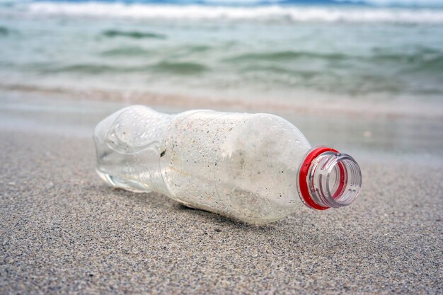 Close-up of obsolete bottle on sandy beach