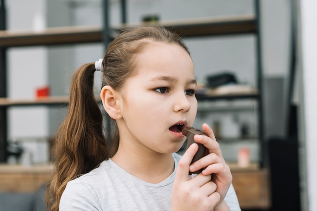 Фото Крупный план девушки, держащей астмы ингалятор перед ее ртом