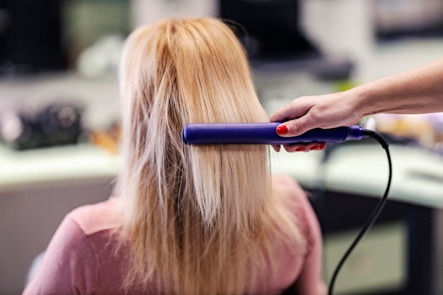 Фото Крупным планом парикмахер гладит волосы клиента в салоне