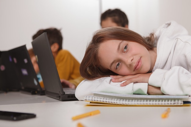 Фото Крупным планом прекрасная девочка-подросток, отдыхая на своих учебниках