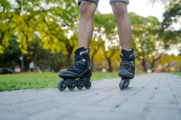 路上で屋外でローラースケートをしている男性のクローズアップ。スポーツの概念。