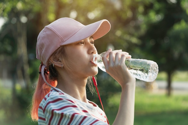 運動後のボトルから水を飲む女性のクローズアップ。飲む女性の肖像画