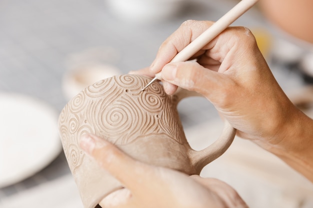 Фото Крупным планом женщины, делающей керамическую и гончарную посуду в мастерской, работая с глиной
