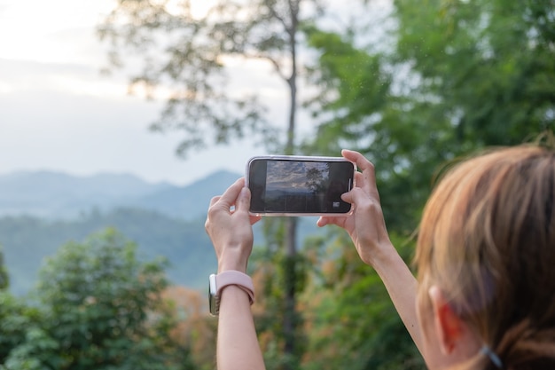 写真 山の写真を撮る少女のクローズアップ