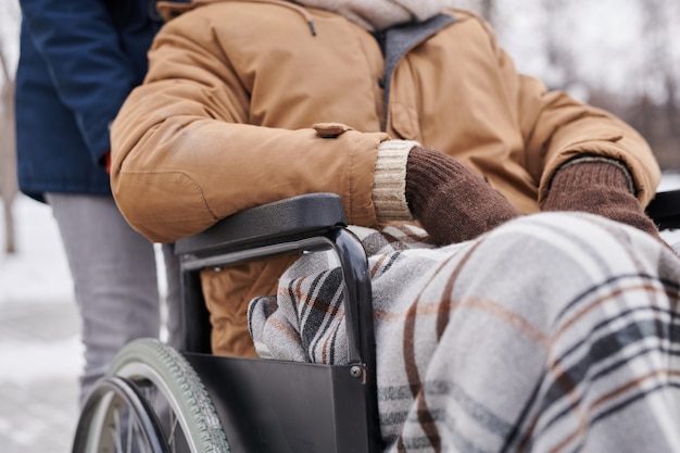 写真 彼の冬の歩行中に暖かい毛布で覆われた車椅子に座っているアフリカ人男性のクローズアップ