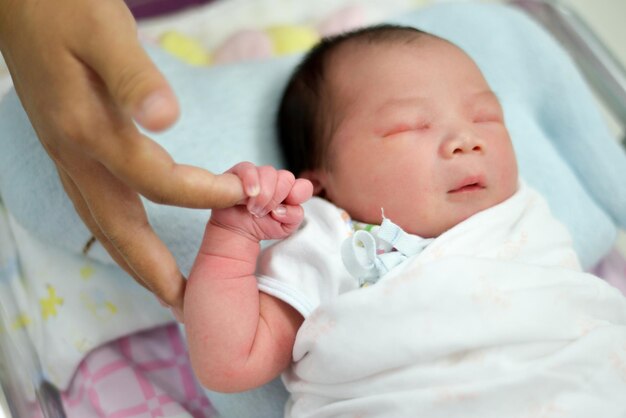 写真 赤ちゃんが指を握っているクローズアップ