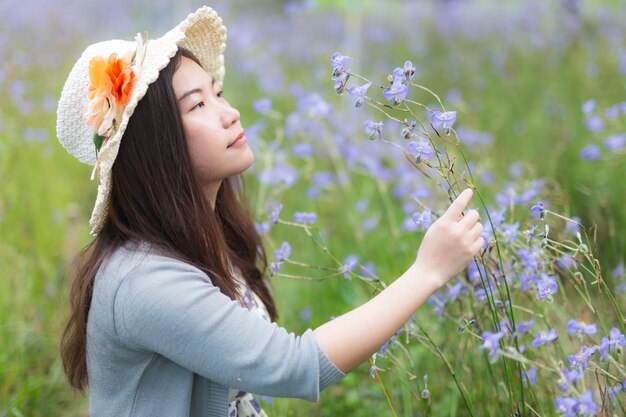 写真 甘いmurdannia giganteum、murdannia giganteumフィールドでのタイの紫色の花と美しいアジアの若い女性のクローズアップ。