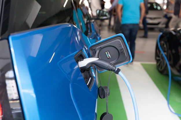 写真 ガソリンスタンドで充電している青い車のクローズアップ