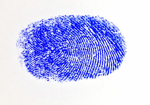 Фото Близкий план отпечатка синего пальца на белом фоне