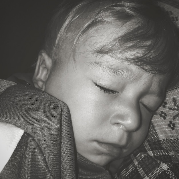 Фото Клоуз-ап мальчика, спящего на кровати.