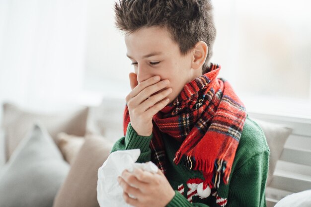 写真 家でくしゃみをしている男の子のクローズアップ