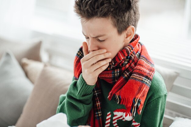 写真 家でくしゃみをしている男の子のクローズアップ