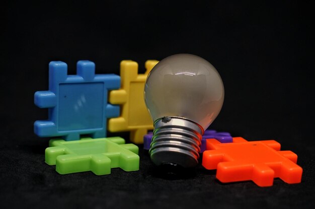 Фото Близкий план лампочки и игрушки на черном фоне