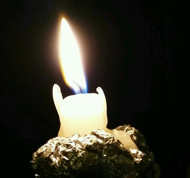 Фото Клоуз-ап горящей свечи в темной комнате