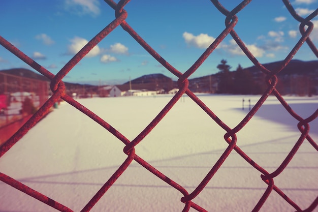 写真 空に照らされたチェーンリンクフェンスのクローズアップ