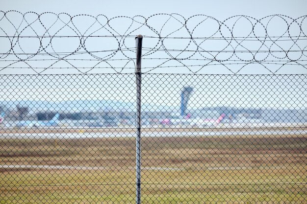 写真 空に照らされたチェーンリンクフェンスのクローズアップ