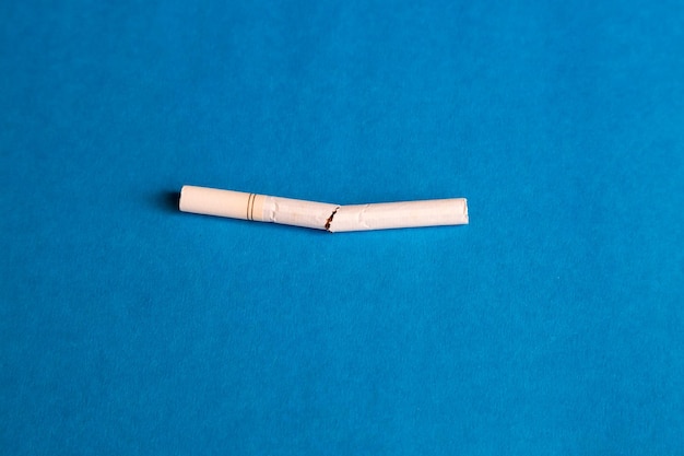 Фото Близкий план сигареты на синем фоне