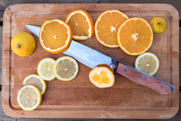 Фото Крупный план цитрусовых с кухонным ножом на доске для резки