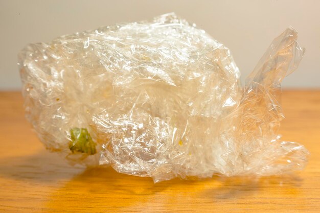 写真 木製のテーブルの上にある折りたたまれたプラスチック袋のクローズアップ