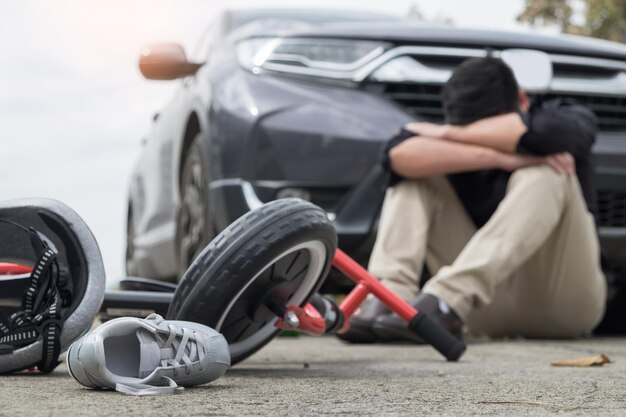 写真 損傷した自転車のクローズアップは道路に座っている男性によって撮影されました