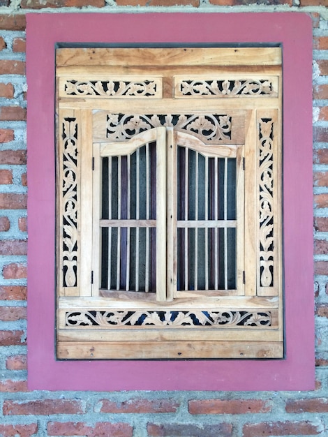 Фото Близкий план украшенного окна на каменном здании