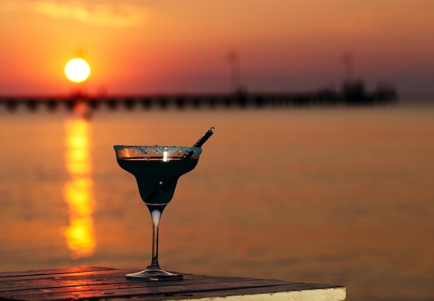 写真 夕暮れの海景色に比べて飲み物のクローズアップ