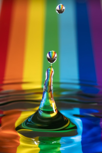 写真 虹のストライプのパターンで水に落ちる滴のクローズアップ