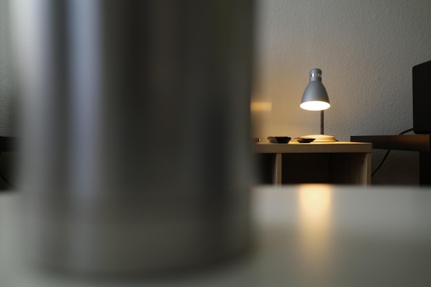 写真 自宅の壁に寄り添ったテーブルの上の電気ランプのクローズアップ