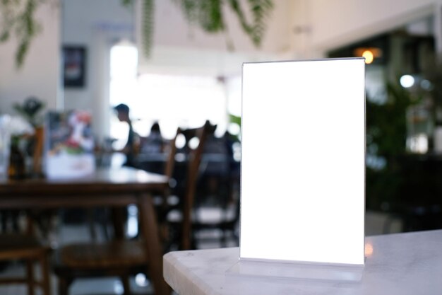 写真 カフェのテーブルの上の空の白い看板のクローズアップ