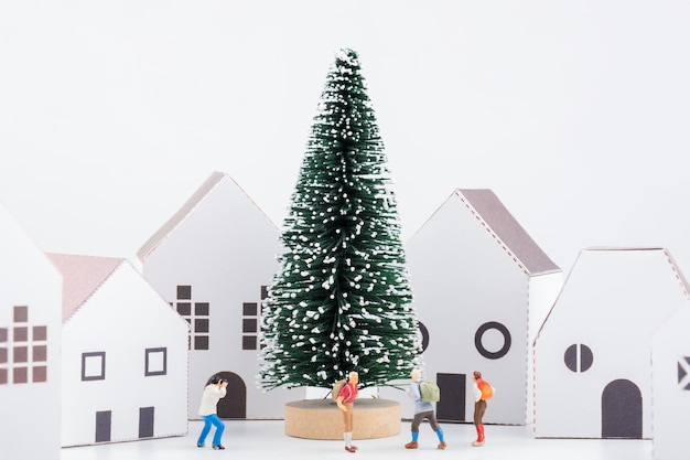 사진 색 배경 에 크리스마스 트리 와 모형 집 을 가진 동상 들 의 클로즈업