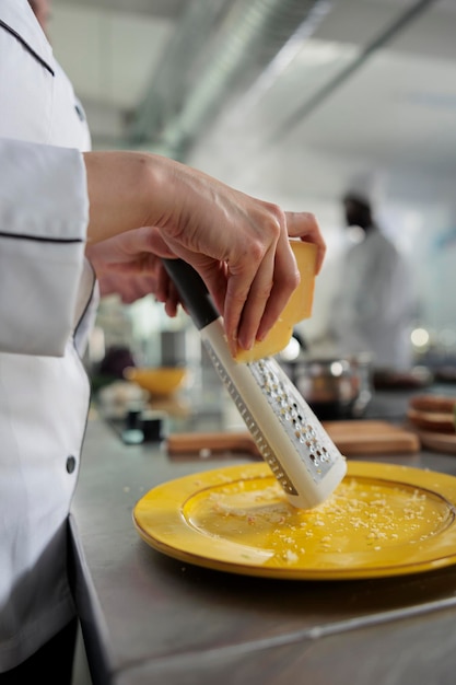 レストランのプロのキッチンで高級ダイニング料理を調理している間、プレート上の美食の専門家の格子チーズのクローズアップ。ディナーサービスで提供されるグルメ料理の材料を準備するスーシェフ。