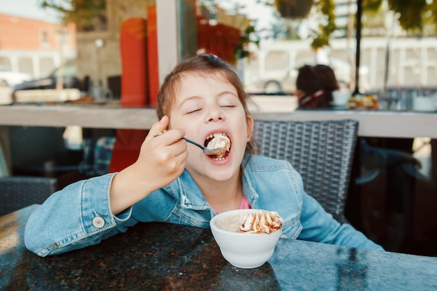 写真 レストランでアイスクリームを食べている女の子のクローズアップ