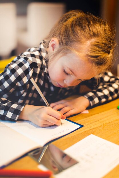 写真 テーブルで勉強している女の子のクローズアップ