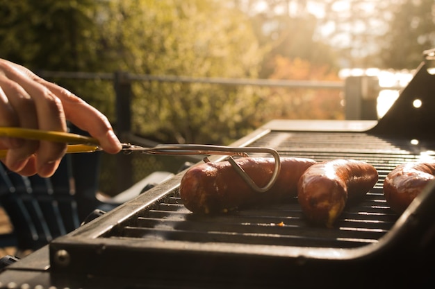 写真 手でソーセージを焼くクローズアップ