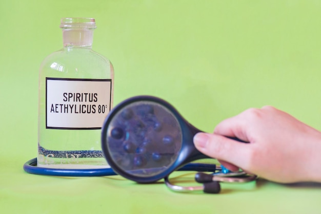 Фото Клоуз-ап бутылки в руке с текстом на столе концепция коронавируса
