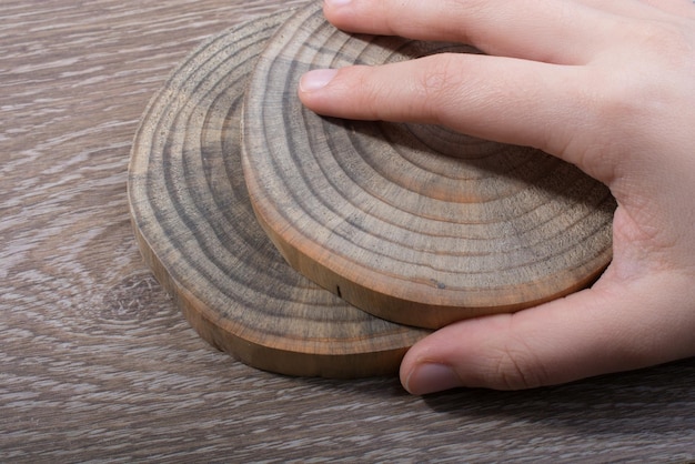 Фото Клоуз-ап руки, держащей древесину за столом
