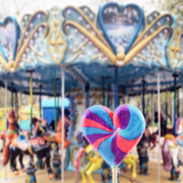 Фото Близкий план конфеты в форме сердца на карусели в парке развлечений