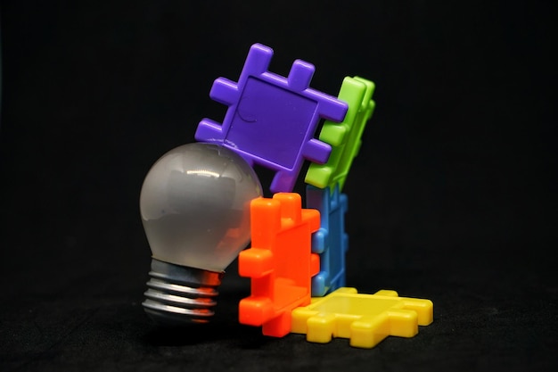 Фото Близкий план лампочки на многоцветных игрушках на черном фоне